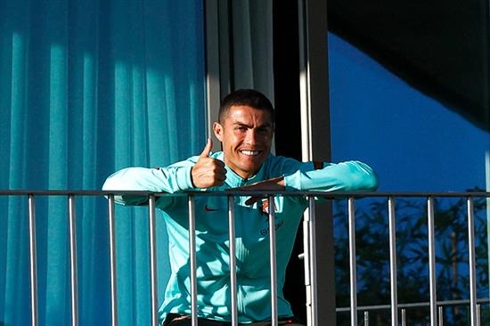 2020年10月13日，葡萄牙，C罗在阳台上晒太阳放风观看队友训练。本文图片 人民视觉